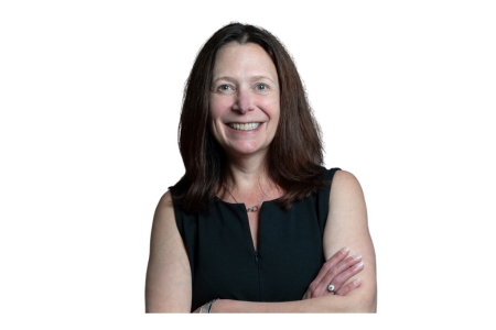 [ai] A woman smiling while standing with her arms crossed, wearing a black sleeveless dress, against a white background.